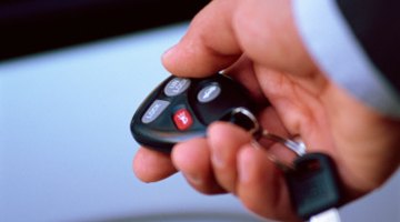 Hand holding remote car entry remote near car door handle