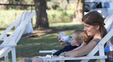 Mother feeding infant girl with a milk bottle