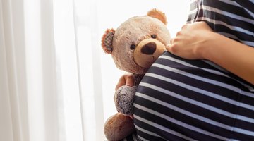 Pregnant woman pulling a suitcase inside airport