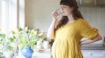 Beautiful pregnant woman drinking water