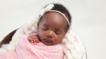 Baby girl yawning in a white round crib