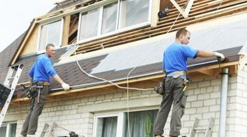 Two men fixing roof on a brick home