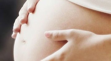 Pregnant woman putting cream on a stomach