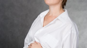 Mid-section view of a woman holding her pelvic area in pain