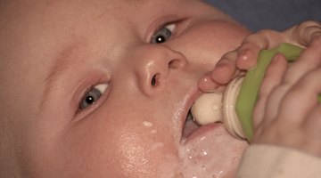 Close-up of a mature man feeding his baby with a bottle