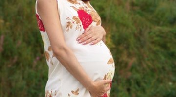 Pregnant woman laying in lawn chair wearing bathing suit