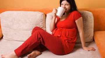 Pregnant woman sitting on a bed