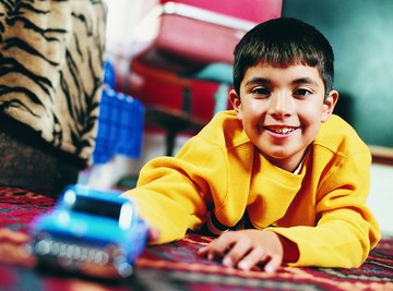 This boy uses force to push this toy car.