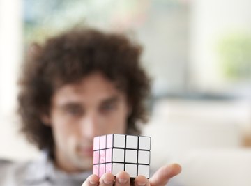 Man holding rubix cube in hand.