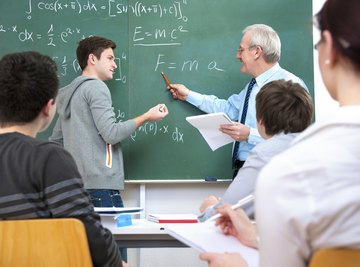 College student working out math problem on chalkboard.