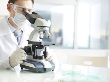 Forensic scientist using microscope