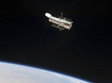 The Hubble Space Telescope floats in space through Earth's exosphere.