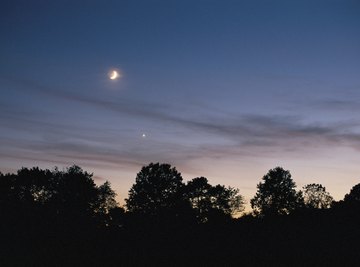 The planet Venus appears just below the moon in the evening sky.