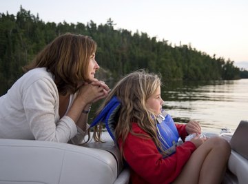 A mother and daughter enjoy a boat ride through the Canadian wilderness.