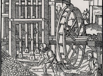 Medieval miners grinding mineral ore at a mill.