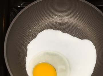 Egg proteins coagulate as they become denatured by heat from a frying pan.