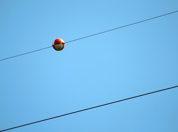 A red ball on a power line.