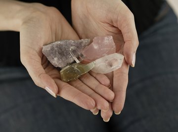 Woman holding various crystal stones in hands.