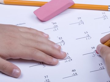 A close-up of a child working on subtraction math problems.