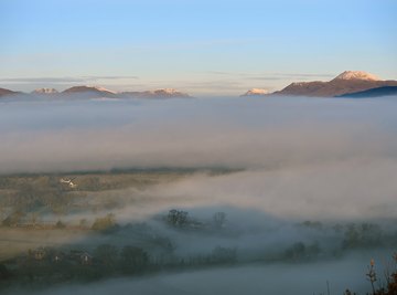 A layer of stratus clouds looming above a mountain tundra.