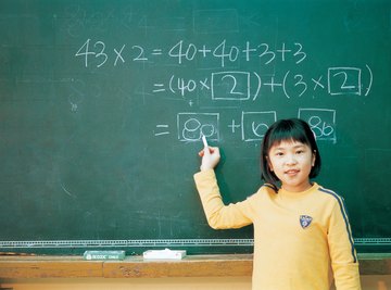 Singapore student practicing math problem on chalkboard