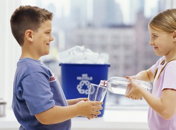 Two young children are drinking water.