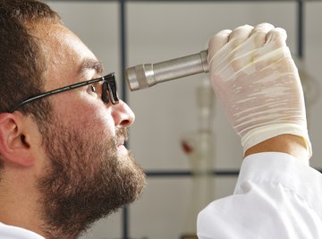 Chemist using a refractometer.