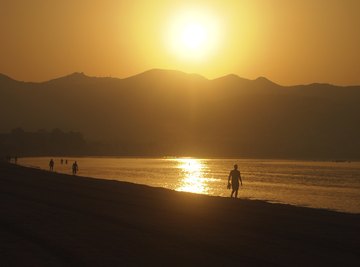 The sun rises over a mountain range.