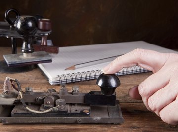 Hand using an antique telegraph machine.