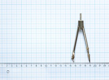 Math compass lying on graph paper