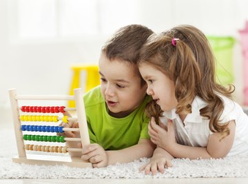 Young students playing with math toy.