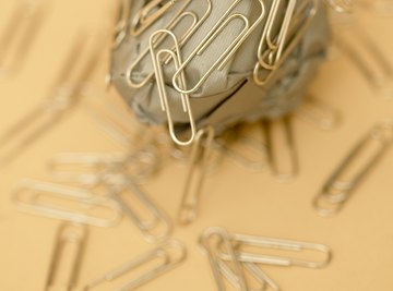 Paper clips attracted to a magnet.