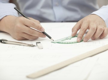 A close-up of an architect using a protractor at his desk.