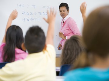 Students raising hands in math class.