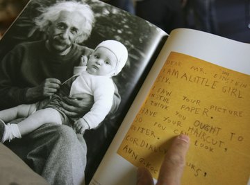 A photo of Albert Einstein with a baby and a letter in a booklet.