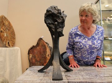 A woman examines a meteorite on display at an art house.