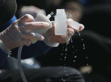 A close-up of a scientist taking water samples for testing.