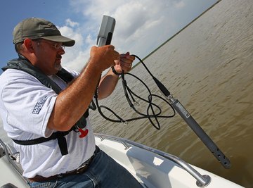 An environmentalist testing the salinity level of a body of water from a boat.