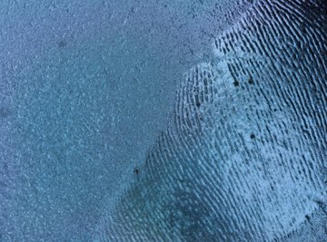 White fingerprint dust is used on dark surfaces.