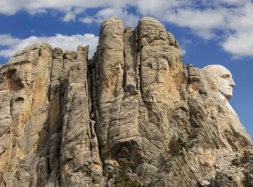 The granite rock of the Mount Rushmore National Memorial shows many stages of weathering.