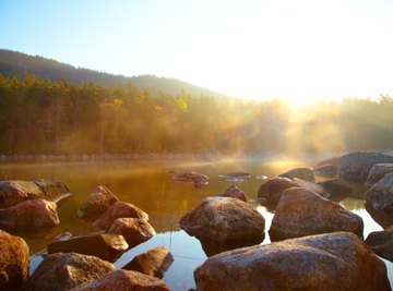 The mechanical weathering of flowing water and rocks striking other rocks causes rocks to become rounded.