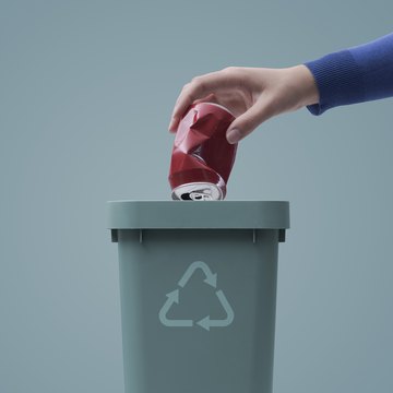 Una persona recibe dinero por reciclar latas.