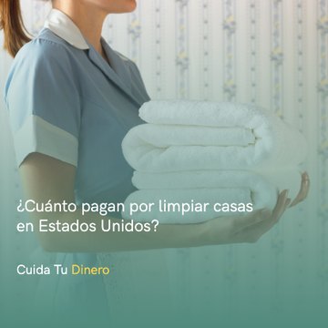 Una empleada de limpieza con toallas limpias y dobladas en sus manos.