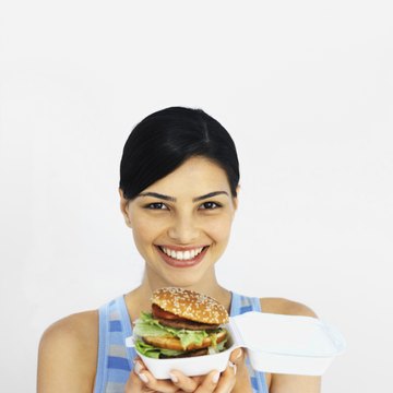 Portrait of a young woman holding a burger