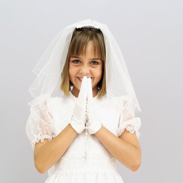 Children traditionally wear white and carry rosaries for First Holy Communion.