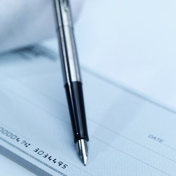 Close-up of cheque book and pen