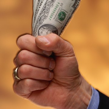 Man's fist gripping US dollars