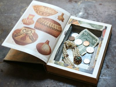 A hollowed-out book conceals small valuables and trinkets.