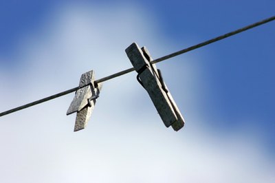 two clothes pins image by Jaroslav Machacek from Fotolia.com Hanging clothes on a line saves electricity and protects the environment.