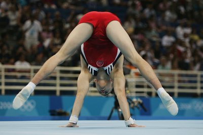 Clive Brunskill/Getty Images Sport/Getty Images Even men use the press handstand to show strength and balance.